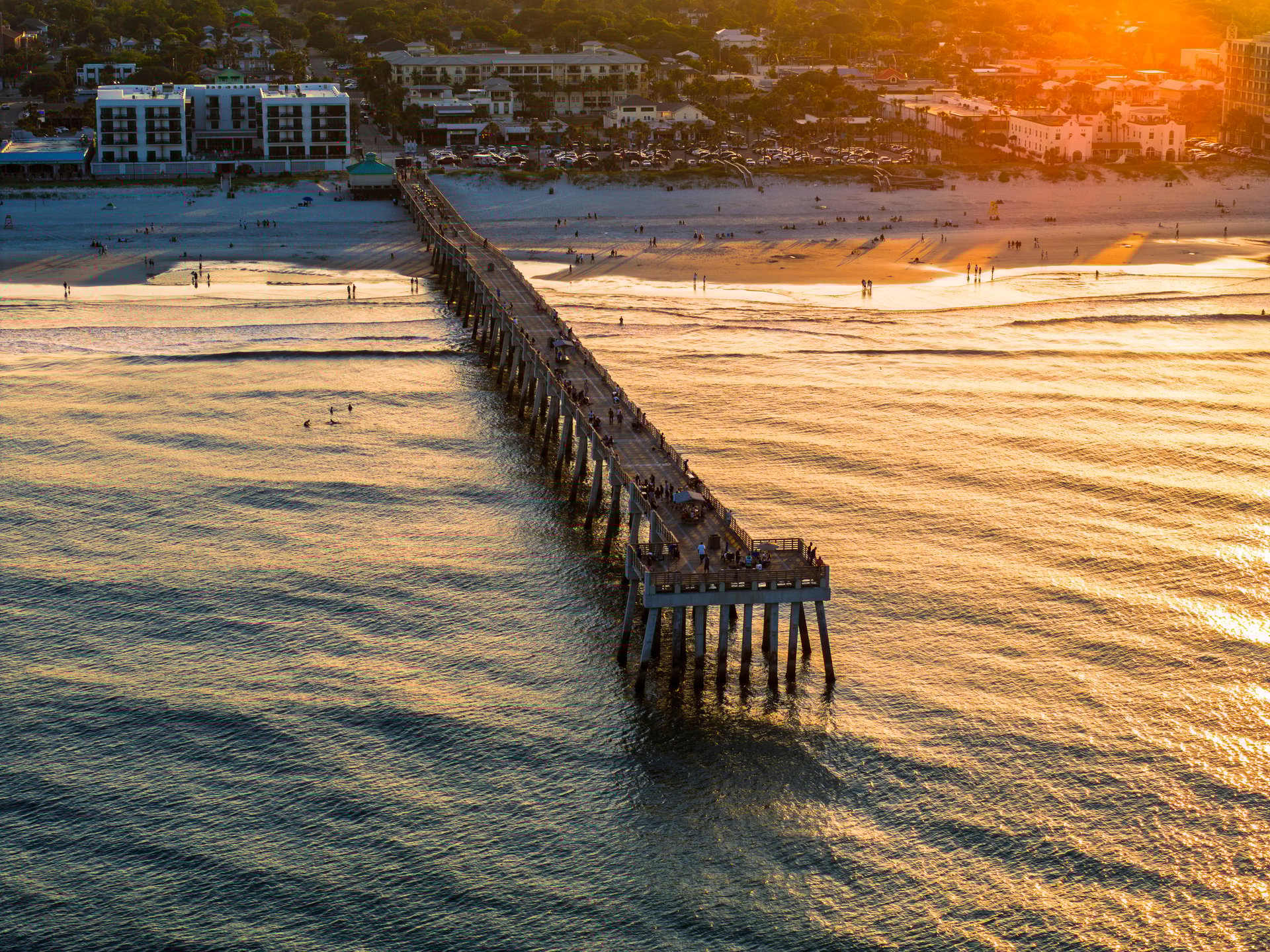Aerial view of the Jacksonville Beach Pier in north Florida during a summer sunset.