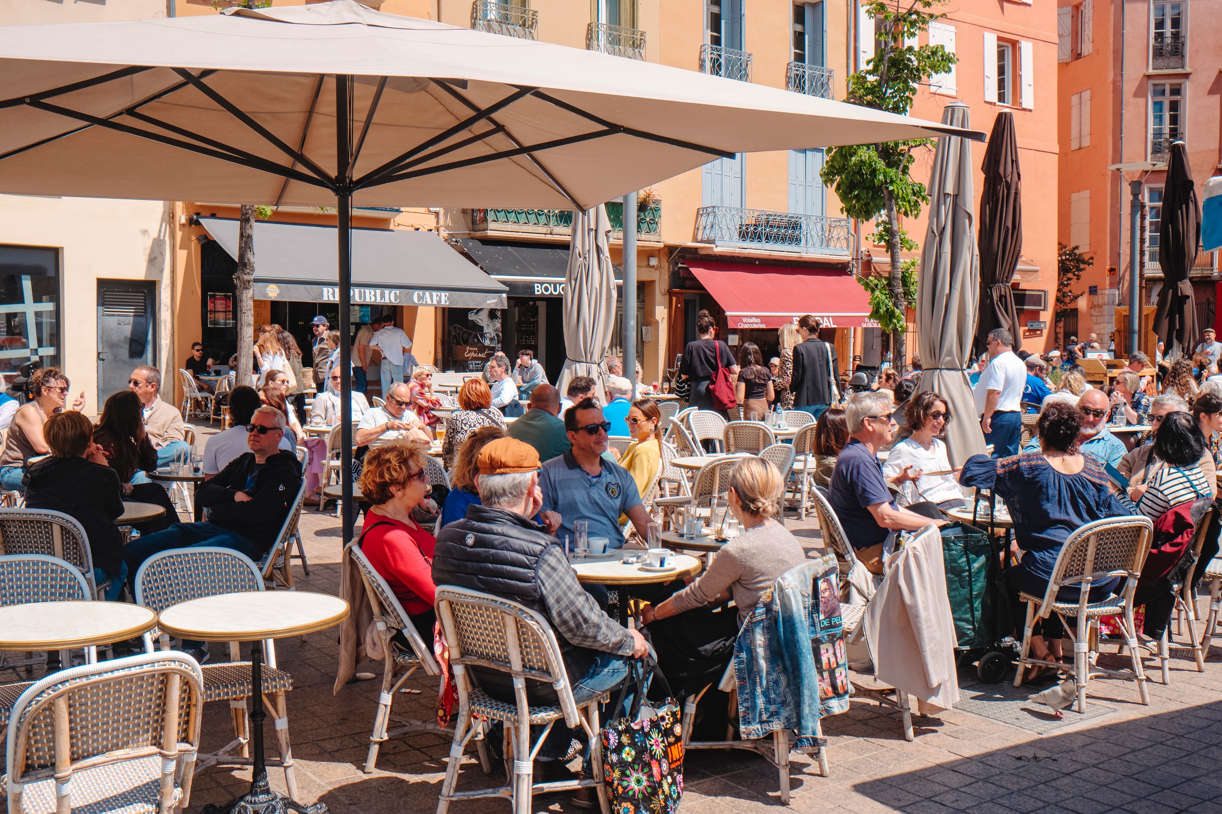 Perpignan, France - May 10, 2025: People enjoying the pleasent weather on a sunny spring saturday at outdoor cafes in Place de la Republique, Perpignan, France