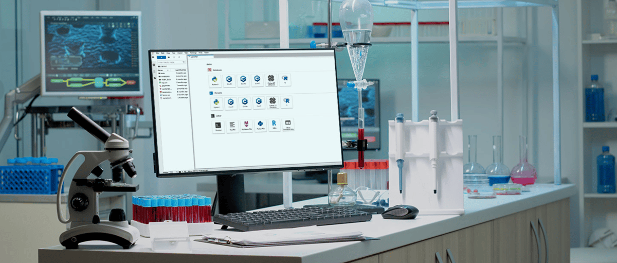 citrine | Iterators A laboratory workspace featuring a microscope and test tubes filled with blood on a counter next to a computer monitor displaying scientific software. The lab is equipped with scientific glassware, pipettes, and flasks containing colorful liquids. In the background, there is another screen showing a digital scientific interface, and laboratory equipment and chemical bottles are visible on shelves.