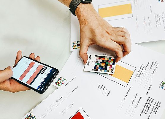A photo of a hand holding a phone and working on their brand identity