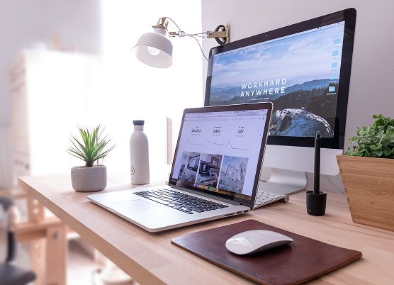 A setup of a laptop and monitor on a sleek and clean modern desk