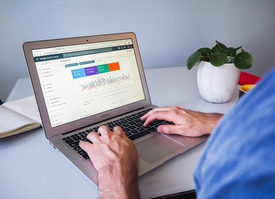 a man working on a laptop displaying advertising information