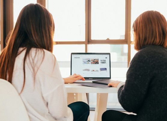 people having a direct conversation in front of a laptop