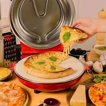 صانعة البيتزا الكهربائية (Pizza Maker) ذات القاعدة الحجرية من ماركة Anko. هذا الجهاز مصمم خصيصاً لطهي البيتزا المنزلية الطازجة أو المجمدة بجودة تقارب أفران الحجر الاحترافية في غضون دقائق معدودة.
💡 طريقة الاستخدام الأساسية:
1. التحضير المسبق: ضع الجهاز على سطح مستوٍ ومقاوم للحرارة.
2. التسخين: قم بتوصيل صانعة البيتزا بالكهرباء وتشغيلها على أقصى درجة حرارة لـ مدة 5 إلى 10 دقائق لكي يسخن الحجر الحراري تماماً.
3. الخبز: انقل عجينة البيتزا مع المكونات برفق إلى الحجر الساخن باستخدام مجاديف البيتزا المرفقة (Pizza Peels).
4. التوقيت: أغلق الغطاء ودعها تخبز؛ تستغرق البيتزا عادةً من 3 إلى 5 دقائق فقط لتصبح مقرمشة وجاهزة