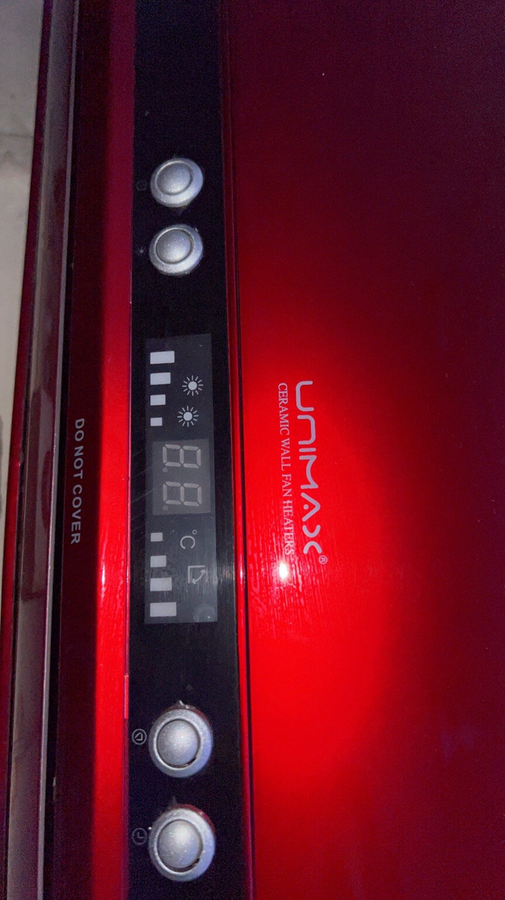 � هذا دفاية/سخان جداري كهربائي من نوع UNIMAX Ceramic Wall Fan Heater، يعني يدفّي الغرفة عن طريق مروحة تدفع الهواء الدافئ.
طولة 3 اشبار صغير 
من الصورة:

* الزرّين على اليسار: غالبًا للتحكم بالتشغيل واختيار وضع التسخين.
* الشاشة بالنص: تعرض درجة الحرارة والإعدادات.
* الزرّين على اليمين: للتحكم بدرجة الحرارة أو بعض الأوضاع حسب الموديل.
* مكتوب DO NOT COVER يعني ممنوع تغطية الدفاية أثناء التشغيل، لأن هذا ممكن يسبب ارتفاع حرارة وخطر.
* الفتحات السفلية هي لخروج الهواء الداف