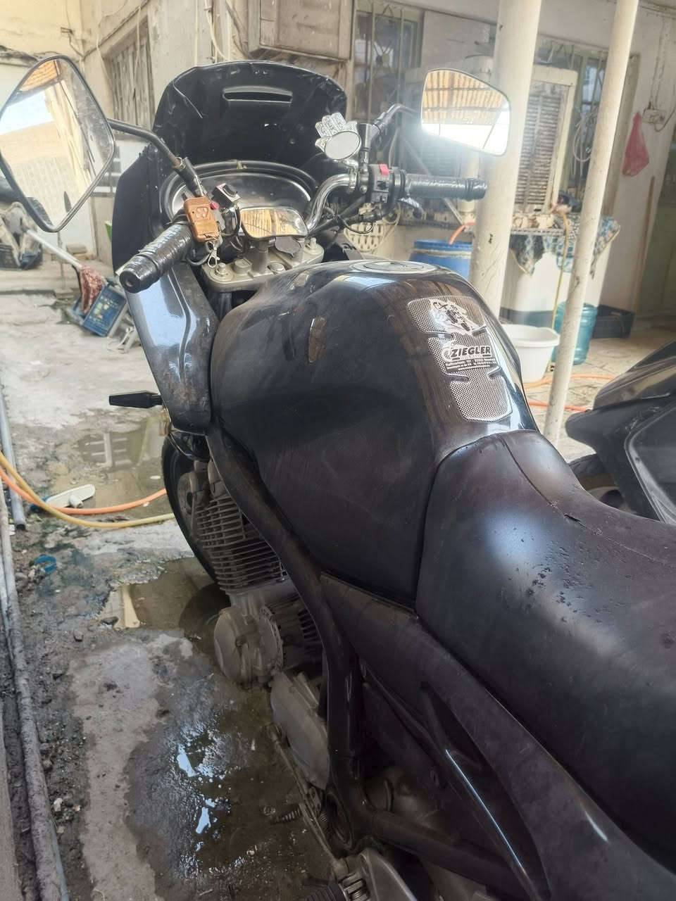 إليك مواصفاتها الأساسية باختصار:
• المحرك والأداء: تتوفر بمحرك 4 سلندر خطي، بسعة 892 سي سي، تنفس طبيعي (كربراتير). يولد قوة تصل إلى حوالي 90 حصان وعزم دوران قوي عند الدورات المتوسطة.
MCN
2+ ...cle News
• نظام التبريد: تبريد هوائي بالكامل. ®
• ناقل الحركة (الكير): يحتوي على 5 سرعات، وتتميز بنظام نقل حركة نهائي عن طريق عمود دوران (شفت / Cardan Shaft)
بدلاً من الجنزير (الزنجيل)، مما يقلل من الحاجة للصيانة الدورية.
• الوزن والهيكل: دراجة ثقيلة نسبياً بوزن يقارب 239 كغم (جافة)، مما يمنحها استقراراً عالياً جداً على الخطوط السريعة وفي السفر.
سعة خزان الوقود (التانكي) ضخمة وتصل إلى 24 لتر.
• الاستخدام والراحة: مصممة كدراجة سياحية (Sport
وتوفر وضعية جلوس مريحة ومقعداً واسعاً منا ( i
للمسافات الطويلة، وتشتهر بنعومة محركها وعمريته الطويلة_مكاني بغداد الحريه-_-(السعر37$) _-_-(***********)
