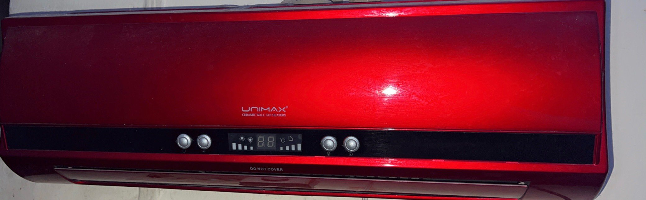 � هذا دفاية/سخان جداري كهربائي من نوع UNIMAX Ceramic Wall Fan Heater، يعني يدفّي الغرفة عن طريق مروحة تدفع الهواء الدافئ.
طولة 3 اشبار صغير 
من الصورة:

* الزرّين على اليسار: غالبًا للتحكم بالتشغيل واختيار وضع التسخين.
* الشاشة بالنص: تعرض درجة الحرارة والإعدادات.
* الزرّين على اليمين: للتحكم بدرجة الحرارة أو بعض الأوضاع حسب الموديل.
* مكتوب DO NOT COVER يعني ممنوع تغطية الدفاية أثناء التشغيل، لأن هذا ممكن يسبب ارتفاع حرارة وخطر.
* الفتحات السفلية هي لخروج الهواء الداف