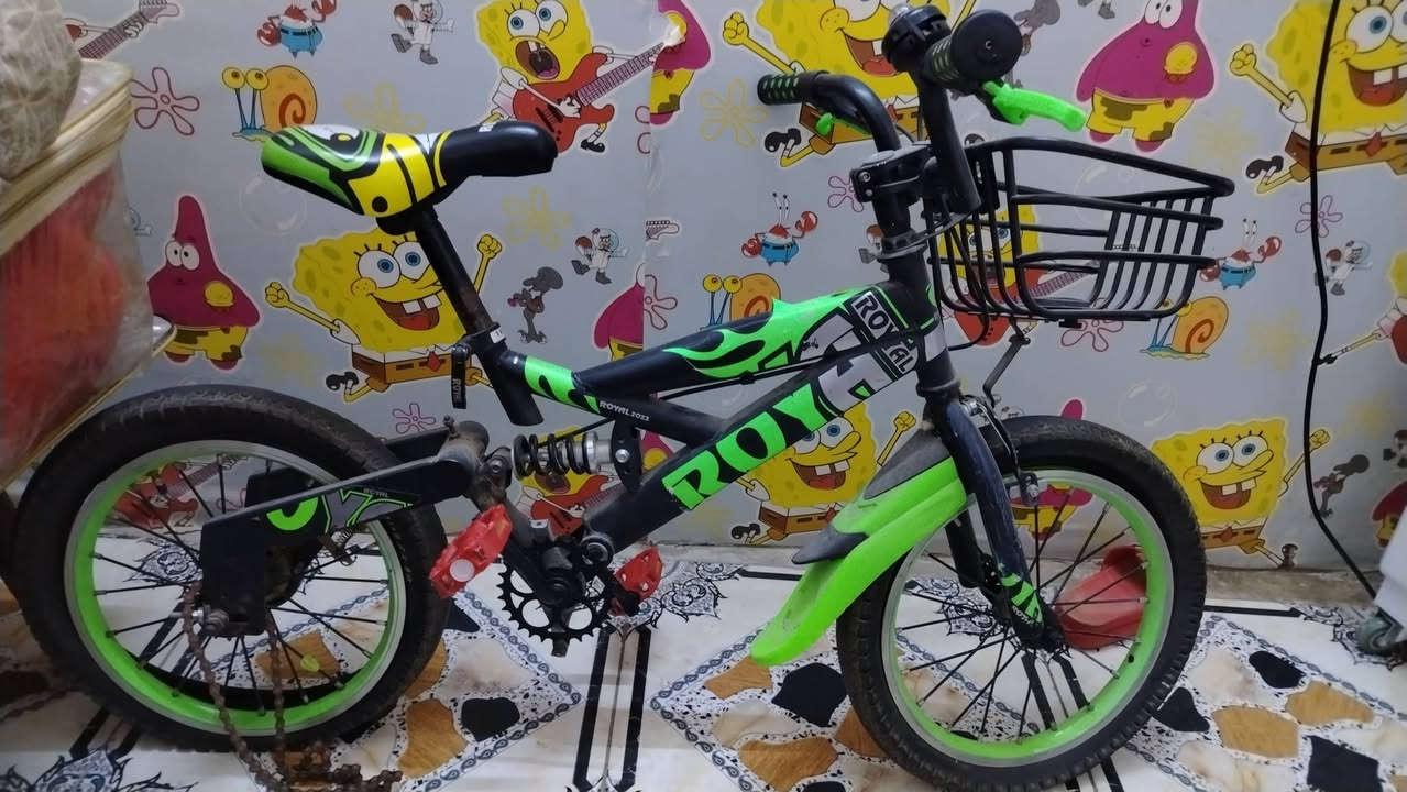 الصورة تعرض بايسكل أطفال رياضي بلون أسود وأخضر من شركة TF Boys، ويتميز بوجود سلة أمامية ومساعد خلفي بتصميم مشابه لدراجات الجبل. السعر ١٥ ابيع فحم يوجد توصيل
