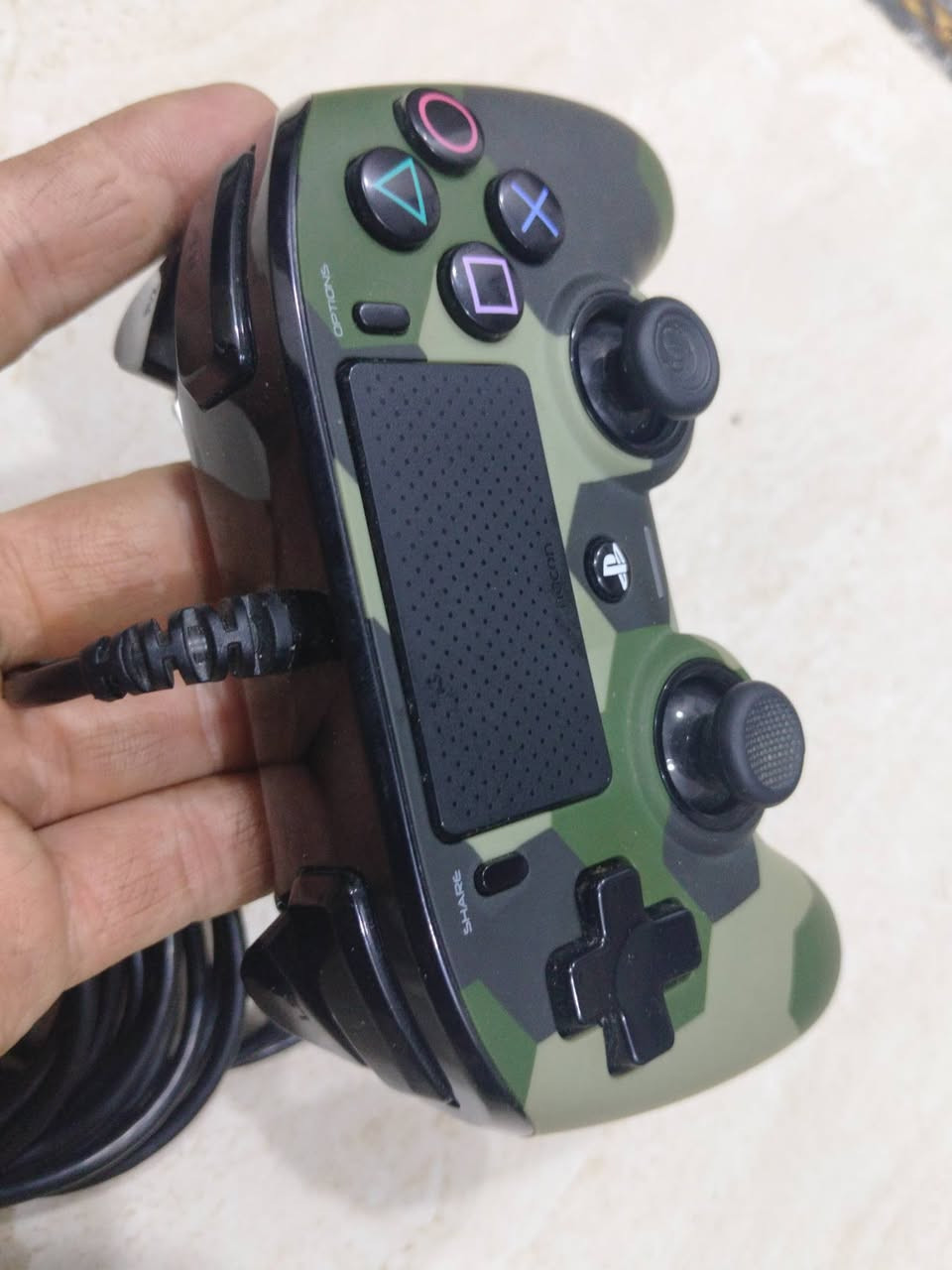 اصلية للبيع بسعر 25.000 نسبة النظافة 99% 
يد التحكم السلكية Nacon Wired Compact Controller هي واحدة من أشهر البدائل الاقتصادية ليد التحكم الأصلية (DualShock 4)، وهي مرخصة رسمياً من شركة Sony.إليك شرح مفصل لأبرز مواصفاتها ومميزاتها، بالإضافة إلى تقييم جودتها بناءً على مراجعات اللاعبين:⚙️ المواصفات والميزات الأساسيةالاتصال سلكي بالكامل: تأتي بكابل مدمج طويل يبلغ طوله 3 أمتار، مما يمنحك استجابة سريعة جداً بصفر تأخير (0 Input Lag)، كما يخلصك من مشكلة شحن البطارية أو تلفها بمرور الوقت.التوافق الكامل: تعمل مباشرة بمجرد التوصيل (Plug and Play) على جهاز PS4 (بما في ذلك نسخة Pro و Slim) وأيضاً على أجهزة الكمبيوتر (PC).المكونات الأساسية: تحتوي على جميع الميزات الأساسية ليد البلايستيشن الأصلية، مثل لوحة اللمس (Touchpad)، ومحركات الاهتزاز المزدوجة، ومنفذ 3.5 ملم لتوصيل سماعات الرأس مباشرة باليد.التصميم الخارجي: السطح مغطى بطبقة مطاطية ناعمة (Rubber Layer) تمنع انزلاق اليد أثناء اللعب الطويل وتوفر قبضة ممتازة
