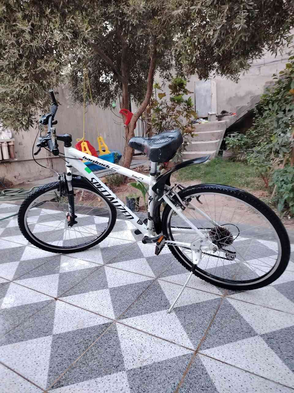 السلام عليكم
بايسكل للبيع

النوع: *SPECIALIZED Hardrock* اصلي امريكي
الحجم: 26 جبلي
المواصفات:
- شاصي المنيوم خفيف ونظيف لون ابيض
- دبلات امامية RST شغالات
- كير شيمانو 21 سرعة ( 3 امام 7 خلف ) 
- بريك V امامي خلفي
- تايرات جديدة دبل عريض مال جبلي
- كرسي طبي مريح + طينيات + ستاند

الحالة: نظيف كلش وشغال مابي اي نقص، بس اغسله وتطلع بيه

السعر: [200وبي مجال ] وبيه مجال بسيط

للتواصل: [رقمك]

--***********-

