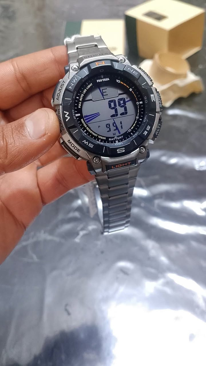 (Casio Pro Trek PRG-340T)
جديد وكالة مع العلبة والملحقات 
تتميز هذه الساعة المخصصة للمغامرين ومحبي الأنشطة الخارجية بمجموعة شاملة من المواصفات والميزات المتقدمة. 
الميزات الرئيسية:
الطاقة الشمسية (Tough Solar): تعمل الساعة بنظام الشحن الشمسي، مما يلغي الحاجة لتغيير البطاريات ويضمن التشغيل المستمر. 
المستشعر الثلاثي (Triple Sensor): تتضمن بوصلة رقمية، مقياس ارتفاع، مقياس ضغط جوي، ومقياس حرارة لتوفير بيانات دقيقة عن البيئة المحيطة. 
مقاومة الماء: مقاومة للماء حتى عمق 100 متر (10 بار)، مما يجعلها مناسبة للسباحة والأنشطة المائية. 
هيكل وسوار من التيتانيوم: السوار والهيكل مصنوعان من التيتانيوم خفيف الوزن وعالي المتانة. 
شاشة LCD مزدوجة: تتميز بشاشة عرض مزدوجة الطبقات لرسومات البوصلة ووظائف الساعة، مما يسهل القراءة. 
مواد حيوية صديقة للبيئة: صُنع الهيكل وبعض المكونات من مواد بلاستيكية حيوية (Bio-based resin) للمساهمة في الحفاظ على البيئة. 
المواصفات والوظائف الإضافية:
إضاءة LED تلقائية بالكامل: توفر إضاءة خلفية واضحة في الظلام. 
التوقيت العالمي: تعرض التوقيت لـ 31 منطقة زمنية مختلفة (48 مدينة). 
ساعة إيقاف ومؤقت: تتضمن ساعة إيقاف دقيقة ومؤقت عد تنازلي. 
منبهات يومية: تحتوي على 5 منبهات يومية مع إشارة الوقت بالساعة. 
عرض شروق وغروب الشمس: ميزة مفيدة لعشاق الطبيعة والمغامرين. 
مقاومة درجات الحرارة المنخفضة: تعمل بكفاءة في درجات حرارة تصل إلى -10 درجات مئوية. 
تقويم تلقائي كامل. 
حجم العلبة (الطول × العرض × الارتفاع)
54.7 × 51.7 × 15.1 مم
وزن الساعة. 87 غرام
