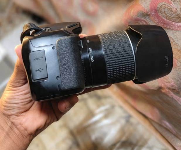 هاي *Canon EOS 4000D* ويا عدسة *Canon EF 75-300mm f/4-5.6 III*

هاي من كامرات كانون المشهورة للمبتدئين، يسموها بالخليج Rebel T100.

### مواصفاتها بالتفصيل:

*البودي - EOS 4000D:*
- *السنسور:* APS-C 18 ميكا بكسل
- *المعالج:* DIGIC 4+
- *التصوير:* تصور 3 صور بالثانية
- *الفيديو:* Full HD 1080p
- *الفوكس:* 9 نقاط فوكس
- *الشاشة:* 2.7 انچ ثابتة
- *الواي فاي:* بيها واي فاي تنقل الصور للموبايل مباشرة
- *البطارية:* تصور حوالي 500 صورة بالشحنة

*العدسة - 75-300mm:*
- هاي عدسة زوم بعيد كلش، تقرب من 75mm الى 300mm
- تفيد للتصوير البعيد - اعراس بالقاعة، طيور، سفرات، ملعب
- بيها واقية شمس ET-60II الي راكبة گدام
- عيبها: ما بيها مانع اهتزاز، يعني لازم تثبت ايدك زين بالشمس

*325 الف دينار*  رقم الاستفسار /***********
