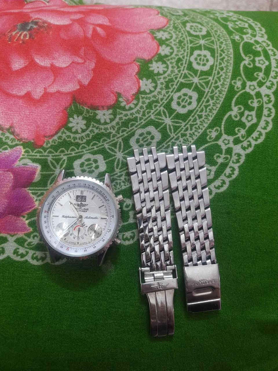 هذه الساعة هي Breitling Chronomat (ساعة كرونوغراف من شركة بريتلينغ السويسرية)، وتحديداً موديل يحمل الرقم A68052.
سعرها 75 وبيها مجال ​إليك التفاصيل والمواصفات بناءً على ما هو موضح على الغطاء الخلفي:
​الموديل / الرقم المرجعي: A68052  
​تاريخ الإنتاج / الإطلاق: تم إنتاج هذا الموديل المزين بنقش التوربين المحرك على الغطاء الخلفي تقريباً في أواخر التسعينيات (حوالي عام 1998 - 1999).
​النوع: كرونوغراف (Chronographe) ميكانيكي/أوتوماتيكي.  
​مكان الصنع: صناعة سويسرية (Manufacture en Suisse).  
​مقاومة الماء: مقاومة للماء حتى عمق 50 متراً (Etanche 50M).  
​الرقم التسلسلي الخاص بالقطعة: No 7771.
 هذه الساعة هي Breitling Chronomat (ساعة كرونوغراف من شركة بريتلينغ السويسرية)، وتحديداً موديل يحمل الرقم A68052.
