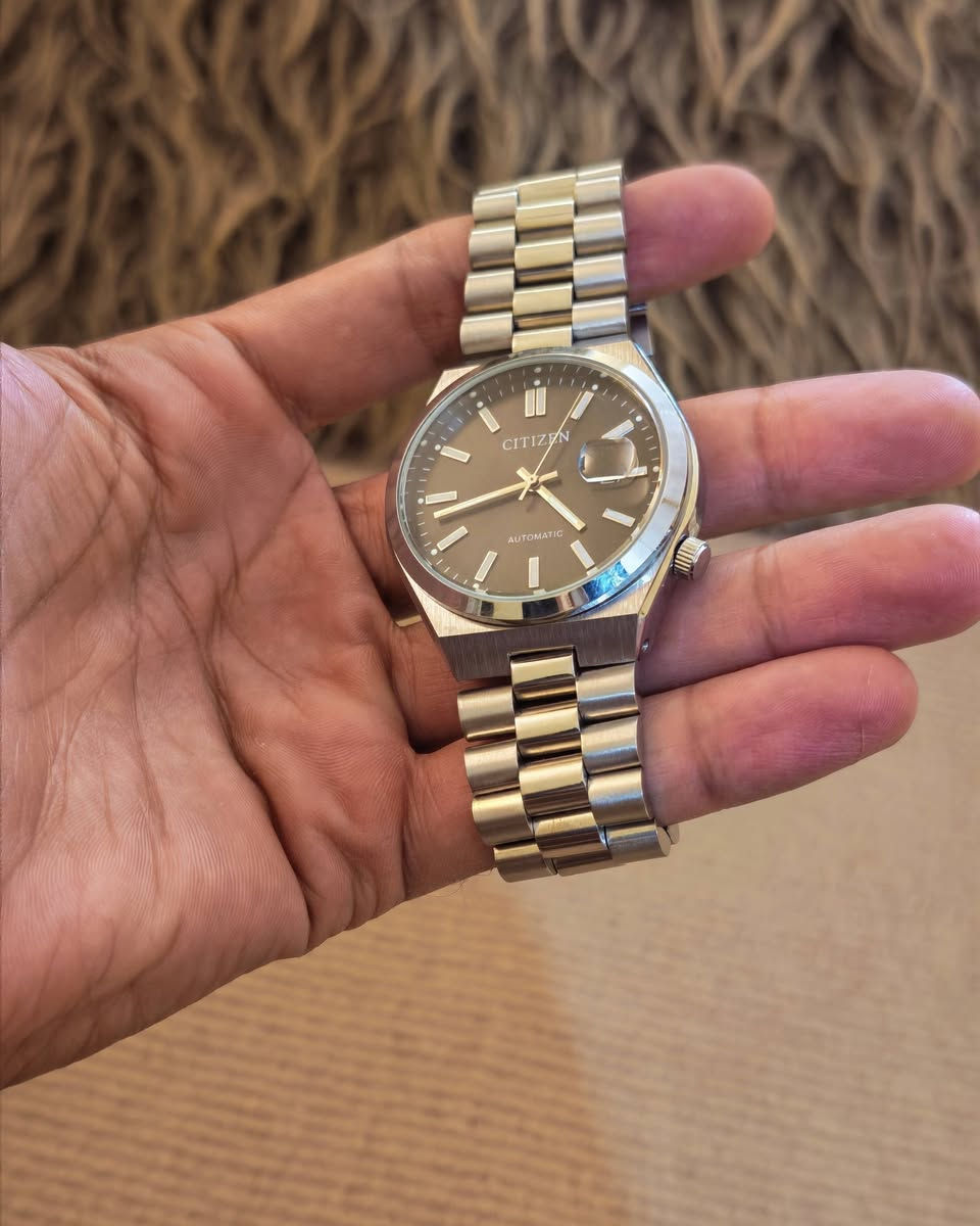 يا الله
ساعة سيتيزن (Citizen)، وتحديداً من مجموعة تسويوسا أوتوماتيك (Tsuyosa Automatic) الشهيرة.المواصفات الأساسية للساعة:نوع الحركة: أوتوماتيكية (تلقائية) تعمل بحركة المعصم.قطر العلبة: 40 ملم.مادة الصنع: فولاذ مقاوم للصدأ (ستانلس ستيل) للعلبة والسوار.تصميم المينا: مينا باللون الرمادي الداكن مع عقارب ومؤشرات ساعات ذات لمعان ذهبي أنيق.نافذة التاريخ: تقع عند مؤشر الساعة 3 مع عدسة مكبرة لقراءة التاريخ بسهولة.مقاومة الماء: مناسبة للاستخدام اليومي البسيط ورذاذ الماء (حتى عمق 50 متراً).
***********
