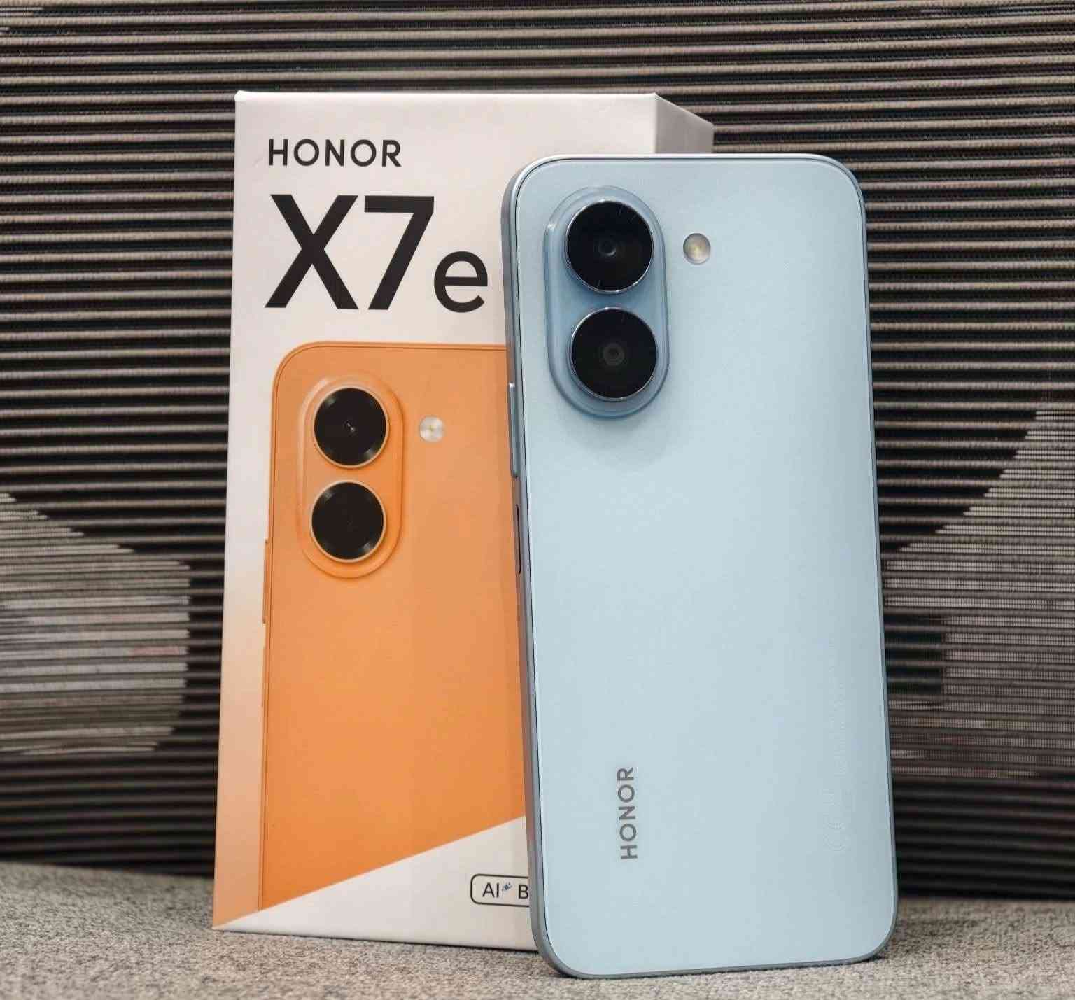 أداء HONOR X7e بالألعاب
PUBG Mobile: تقريباً 40 FPS على إعدادات مناسبة.
Call of Duty Mobile: حوالي 40–60 FPS حسب الإعدادات.
Free Fire: يوصل تقريباً 60 FPS بإعدادات مناسبة.
eFootball: أداء جيد، لكن ممكن تنخفض الإطارات بالمباريات الثقيلة.
الألعاب الثقيلة: يفضل تلعب على إعدادات متوسطة أو منخفضة حتى يبقى الأداء ثابت.
📌 الخلاصة: الجهاز مناسب للألعاب اليومية والمتوسطة، لكن مو مخصص للألعاب الثقيلة بأعلى جودة.📱 الشاشة
الحجم: 6.61 إنچ
النوع: TFT LCD
الدقة: 720 × 1604
التحديث: 120Hz
السطوع الأقصى: 1010 nits �
HONOR +١
⚙️ الأداء والذاكرة
المعالج: MediaTek Helio G81 Ultra
الرام: 6GB
التخزين: 128GB أو 256GB
يدعم RAM Turbo؛ نسخة 6GB يمكن أن تظهر كتجربة تصل إلى 12GB باستخدام جزء من التخزين. �
HONOR +١
📸 الكاميرات
الخلفية: 50MP رئيسية
الأمامية: 5MP
تصوير الفيديو: حتى 1080p / 30fps. �
موبایل إيران +١
🔋 البطارية
السعة: 7500mAh (السعة الاسمية 7320mAh)
الشحن السريع: 45W HONOR SuperCharge
تدعم الشحن العكسي السلكي. �
HONOR +١
🛡️ المتانة
مقاومة ماء وغبار: IP64
حاصل على اعتماد SGS لمقاومة السقوط والصدمات
مقاومة سقوط مُختبرة حتى 1.8 متر في ظروف الاختبار المذكورة من HONOR. �
HONOR
📐 الحجم والوزن
الأبعاد: 163.9 × 75.9 × 8.3 ملم
الوزن: حوالي 200 غرام. �
موبایل إيران
🔊 إضافات
بصمة جانبية
سماعات ستيريو
منفذ سماعة 3.5mm
USB-C
شريحتين Nano-SIM
نظام Android 16 مع واجهة HONOR. �
