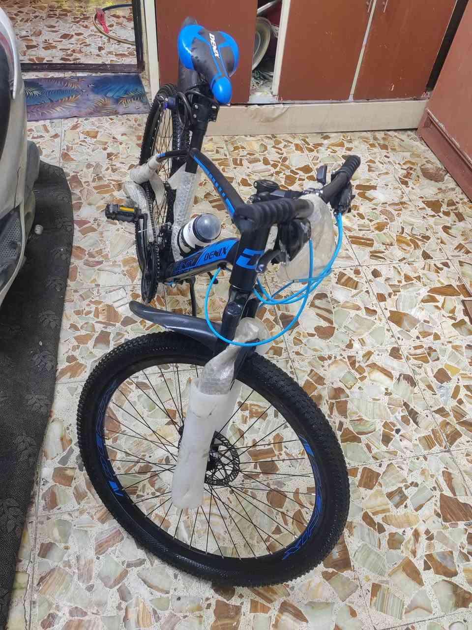 سلام عليكم بايسكل DENIX جبلي - للبيع 🚴‍♂️
​المواصفات والتفاصيل:
​الماركة: DENIX (أصلي).
​النوع: جبلي (Mountain Bike) مناسب للمشي اليومي وللطرق الوعرة.
​الحالة: جديد (مغلف بتغليف الشركة).
​اللون: أسود مع تطعيم أزرق مميز.
​نظام المكابح: ديسك (Disc Brakes) أمامي وخلفي لثبات وقوة توقف.
​المساعدات: دبل أمامي امتصاص صدمات لتنعيم القيادة.
​السرعات: نظام جيرات/دوشج متعدد السرعات تحكم كامل.
​الملحقات المرفقة:
​مطارة ماء مع القاعدة.
​قماريات (قاطعات طين) أمامي وخلفي.
​جك (ستاند) جانبي.
​كمر (سرج) رياضي مريح DENIX.
​📍 المكان: بغداد مدينه الصدر 
📞 للتواصل:  *********** 
💰 السعر:  190
