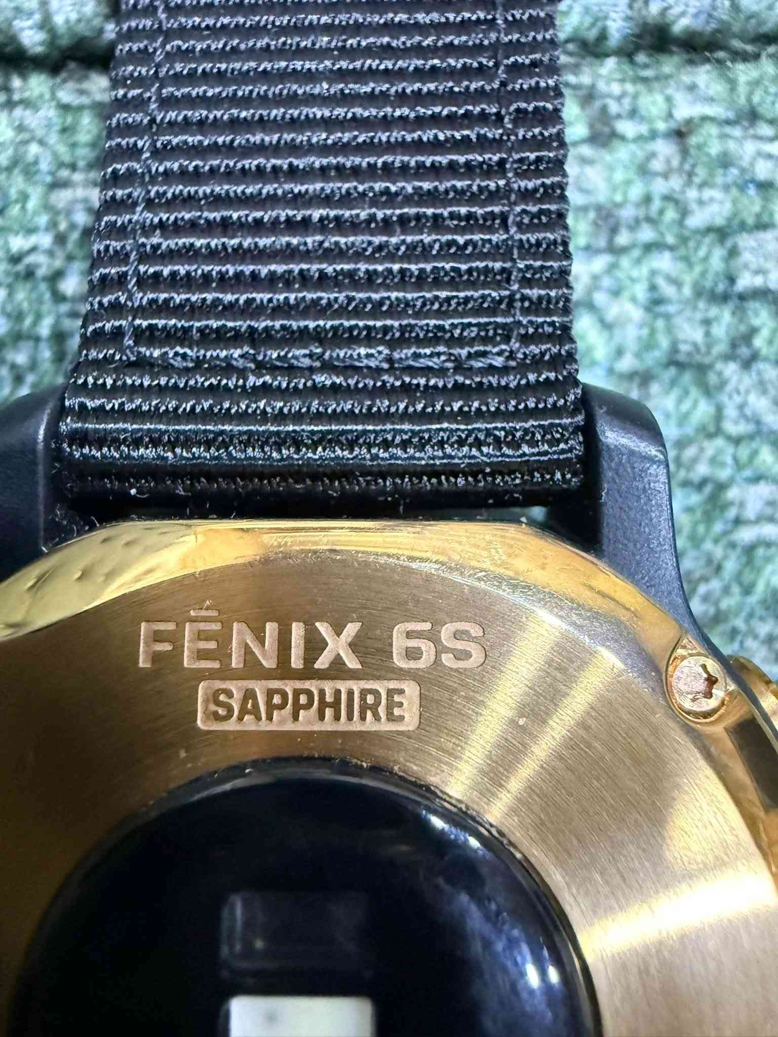 ساعة Garmin Fenix 6S Sapphire
السعر 200 الف مع كيبل نوع Type c لون ذهبي Golden ذهبي مع سير كتان اسود 

الإصدار المدمج والفاخر ضمن سلسلة Fenix 6، والمصممة بحجم أصغر يناسب المعاصم المتوسطة والنحيفة مع شاشة محمية بزجاج الياقوت (Sapphire) المقاوم للخدش.

المواصفات التقنية والتصميم
 أبعاد الهيكل: 42 × 42 × 13.8 مم.
 الوزن: 61 غراماً (الهيكل مع حزام السيلكون).
 حجم الشاشة: 1.2 بوصة (قطر 30.4 مم) بدقة 240 × 240 بكسل.
 نوع الشاشة: شاشة ملونة مرئية تحت أشعة الشمس (MIP - Memory-in-Pixel).
 عدسة الشاشة: زجاج كريستال الياقوت المقاوم للخدش (Sapphire Crystal).
 الإطار والظهر: إطار من الفولاذ المقاوم للصدأ (Stainless Steel) أو الفولاذ المطلي بتقنية DLC، مع غطاء خلفي معدني.
 عرض الحزام: QuickFit مقاس 20 مم.
 مقاومة الماء: 10 ATM (حتى عمق 100 متر).
 السعة التخزينية: 32 جيجابايت.

الأجهزة والاستشعار والملاحة
 أنظمة الملاحة: دعم ثلاثي لأنظمة GPS و GLONASS و Galileo.
 المستشعرات:
 مستشعر نبضات القلب من المعصم (Garmin Elevate).
 مقياس أكسجين الدم (Pulse Ox).
 بوصلة ثلاثية المحاور ومقياس ارتفاع بارومتري (Barometric Altimeter).
 مقياس تسارع (Accelerometer) وميزان حرارة (Thermometer).
 الخرائط: خرائط TopoActive للملاحة، وخرائط مدعمة لأكثر من 2000 منتجع تزلج وملاعب الجولف عالمياً.
الميزات الذكية والرياضية
 تخزين الموسيقى: تتسع لنحو 2000 أغنية مع دعم التطبيقات مثل Spotify وDeezer وإمكانية الاستماع عبر سماعات Bluetooth.
 الدفع الإلكتروني: دعم خدمة Garmin Pay للدفع اللاتلامسي.
 ميزات التدريب Advanced Training:
 مؤشر PacePro لإدارة وتوزيع الجهد أثناء الركض.
 قياس الأداء المتقدم (VO2 Max، حالة التدريب Training Status، الحمل التدريبي).
 ميزة Body Battery لمراقبة مستويات طاقة الجسم.
 مراقبة الجودة والنوم والإجهاد والتنفس.
