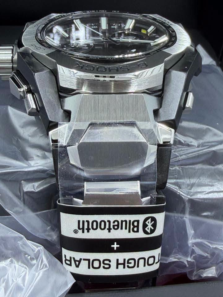 حصرياً لدى السيد للساعات 
السعر 1,500,000
Casio G-Shock MT-G Series 
وهي واحدة من السلسلة الفاخرة اليابانية MT-G التي تجمع بين المتانة الفائقة والتصميم الهيكلي الأنيق باستخدام مزيج من المعدن وألياف الكربون. تم تطوير هندسة هذه السلسلة الفريدة بالتعاون مع تقنيات الذكاء الاصطناعي لتحسين توزيع الوزن وزيادة مقاومة الصدمات.
 كافة التفاصيل، المواصفات، والمميزات الأساسية لهذه الساعة:
. التقنيات الذكية والاتصال (الأعلى تعقيداً)
• اتصال ذكي (Bluetooth® Mobile Link): تتصل الساعة لاسلكياً بالهاتف الذكي عبر تطبيق CASIO WATCHES. يتيح ذلك ضبط الوقت تلقائياً بدقة متناهية، وإعداد الساعة بسهولة، وميزة "الباحث عن الهاتف" (Phone Finder).
• التحكم اللاسلكي بالموجات (Multi-Band 6): تستقبل الساعة إشارات راديو لمعايرة الوقت تلقائياً من 6 محطات بث حول العالم لضمان دقة متناهية حتى بدون هاتف.
• نظام الطاقة الشمسية (Tough Solar): نظام شحن متطور يعمل بالطاقة الشمسية أو أي مصدر ضوء آخر، مما يلغي الحاجة لتغيير البطارية دورياً.
2. البنية والمواد التصنيعية (هندسية متقدمة)
• هيكل حماية النواة المزدوجة (Dual Core Guard): هيكل متطور يدمج بين الراتينج المعزز بألياف الكربون والفولاذ المقاوم للصدأ (Stainless Steel) لحماية الآلية الداخلية من أقوى الصدمات.
• حزام مركب من طبقات (Layered-Composite Band): سوار فاخر مصنوع من قطع معدنية مدمجة مع قطع الراتينج ليوفر وزناً خفيفاً وملمساً مريحاً على اليد مع الحفاظ على المظهر الصلب.
• زجاج ياقوتي (Sapphire Crystal): زجاج فائق النقاء ومقاوم للخدش بنسبة عالية جداً، مزود بطبقة طلاء مضادة للانعكاس لرؤية واضحة في مختلف ظروف الإضاءة.
3. الوظائف الرياضية واليومية (متوسطة التعقيد)
• التوقيت العالمي المتعدد: يدعم 38 منطقة زمنية (تغطي 27 مدينة رئيسية + التوقيت العالمي المنسق UTC)، مع خاصية التبديل التلقائي للتوقيت الصيفي (DST).
• التقويم التلقائي الكامل: يعرض التاريخ واليوم بدقة ولا يحتاج للتعديل حتى في السنوات الكبيسة.
• مؤقت وساعة إيقاف (Stopwatch): لحساب الوقت بدقة أثناء التمارين أو الأنشطة اليومية.
4. المواصفات الأساسية (الأبسط)
• مقاومة الماء حتى 200 متر (20 Bar): تجعلها مناسبة جداً للسباحة، الغوص السطحي، والأنشطة المائية القوية.
• إضاءة LED عالية السطوع (Super Illuminator): تضمن قراءة الوقت بوضوح تام في الظلام الدامس.
• عقارب مضيئة (Neobrite): طلاء فوسفوري على العقارب والمؤشرات يضيء في الظلام بعد تعرضه القصير للضوء.
