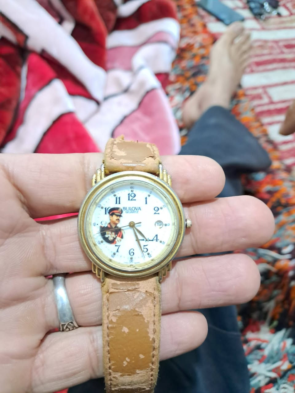 ساعة بولوفا (Bulova) نادرة وتاريخية – إصدار خاص (تذكارية)
​الماركة: بولوفا (Bulova) الأصلية.
​المحرك: كوارتز (بطارية - Japan Movt).
​التفاصيل: تحوي المينا صورة للرئيس الأسبق صدام حسين واسمه باللغة العربية، وهي من القطع التذكارية القديمة الخاصة بهواة الجمع والأنتيكات.
​الجنس والغطاء الخلفي: الغطاء الخلفي ستانلس ستيل (Stainless Steel Back)، الهيكل Base Metal Bezel.
​الحالة: كلاسيكية ومستعملة (توجد آثار احتكاك وتآكل طبيعي على طلاء الهيكل الذهبي والحزام بسب القِدم وزمن القطعة).***********
