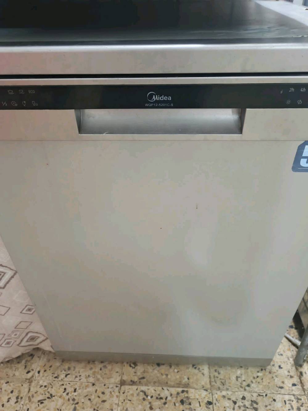 ​المعلومات الأساسية
​الماركة: ميديا (Midea).
​الموديل: WQP12-5201C-S.
​النوع: غسالة صحون قائمة بذاتها (Free-standing).
​اللون: ألومنيوم / فضي مقاوم للبصمات (Silver/Stainless Steel).
​المواصفات الفنية والتصميم
​السعة: تتسع لـ 12 طقم صحون (مناسبة للعائلات المتوسطة).
​التصميم الداخلي:
​رف علوي مخصص للأكواب والأطباق الصغيرة مع حامل أدوات جانبية قابل للطي.
​رف سفلي واسع مخصص للأطباق الكبيرة والقدر.
​سلة متحركة لمقتنيات المائدة (الملاعق والسكاكين والشوَك).
​رشاشات مياه متعددة لتوزيع أفضل للمياه.
​لوحة التحكم: شاشة إلكترونية بشريط أسود وأزرار لمس/ضغط بالوظائف التالية:
​برنامج ECO: للتوفير في استهلاك المياه والكهرباء.
​برنامج نصف الحمولة (1/2): لتشغيل الغسالة بجمع كمية أقل من الصحون لتوفير الطاقة.
​تأخير التشغيل (Delay Start): إمكانية ضبط التوقيت لتأخير البدء (ساعتين، 4 ساعات، إلخ).
​مؤشرات ضوئية لإعادة ملء الملمع (Rinse Aid) والمح والأنظمة.