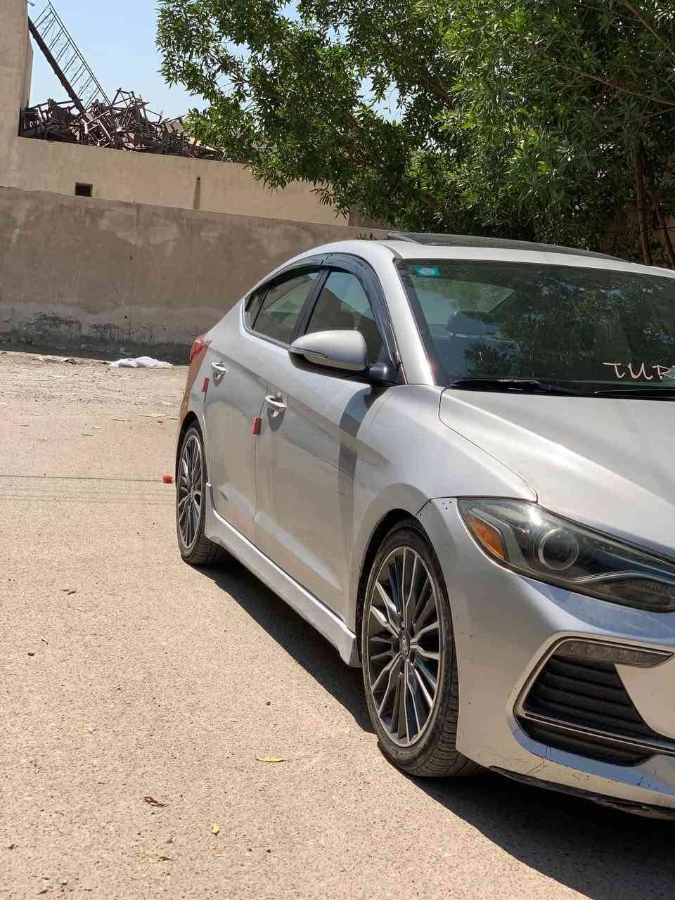 هيونداي النترا 2018 سبورت 1.6 تيربو (وارد أمريكي) – فول مواصفات 🚗
✨ المحرك والأداء

* محرك 1.6 لتر تيربو GDI
* 4 سلندر – حقن مباشر
* قوة 201 حصان
* عزم 265 نيوتن متر (195 رطل/قدم)
* قير أوتوماتيك DCT من 7 سرعات أو يدوي 6 سرعات
* دفع أمامي FWD
* تسارع 0-100 كم/س حوالي 7 ثوانٍ
* وضعية قيادة رياضية Sport Mode  

✨ المواصفات الخارجية

* جنوط رياضية ألمنيوم قياس 18 إنج
* إطارات 225/40 R18
* مصابيح HID أمامية
* LED خلفية
* مرايا كهربائية مع إشارات
* شبك سبورت وتصميم رياضي خاص بفئة Sport
* جناح خلفي رياضي
* فتحة سقف كهربائية

✨ المواصفات الداخلية

* مقاعد جلد رياضية
* مقاعد أمامية مدفأة
* مقود جلد رياضي Flat Bottom
* تشغيل بصمة (Smart Key)
* تشغيل السيارة زر Start/Stop
* شاشة معلومات وسطية
* Apple CarPlay
* Android Auto
* بلوتوث
* USB و AUX
* مثبت سرعة
* تكييف أوتوماتيك
* شاشة معلومات بين العدادات  

✨ أنظمة الأمان

* 6 وسائد هوائية
* ABS مانع انغلاق الفرامل
* ESP نظام الثبات الإلكتروني
* Traction Control
* كاميرا خلفية
* Blind Spot Monitor (تحذير النقطة العمياء)
* Rear Cross Traffic Alert
* Hill Start Assist
* نظام مراقبة ضغط الإطارات TPMS  

✨ مواصفات الشاصي والتعليق

* تعليق رياضي Sport Tuned Suspension
* نظام تعليق خلفي مستقل Multi-Link
* دسكات أمامية كبيرة رياضية
* توجيه كهربائي دقيق EPS
* ثبات ممتاز على السرعات العالية
رقم بغداد Eنكليزي تحويل ثاني يوم
مكان بغداد البياع السعر 103 ابيع سريع
***********
