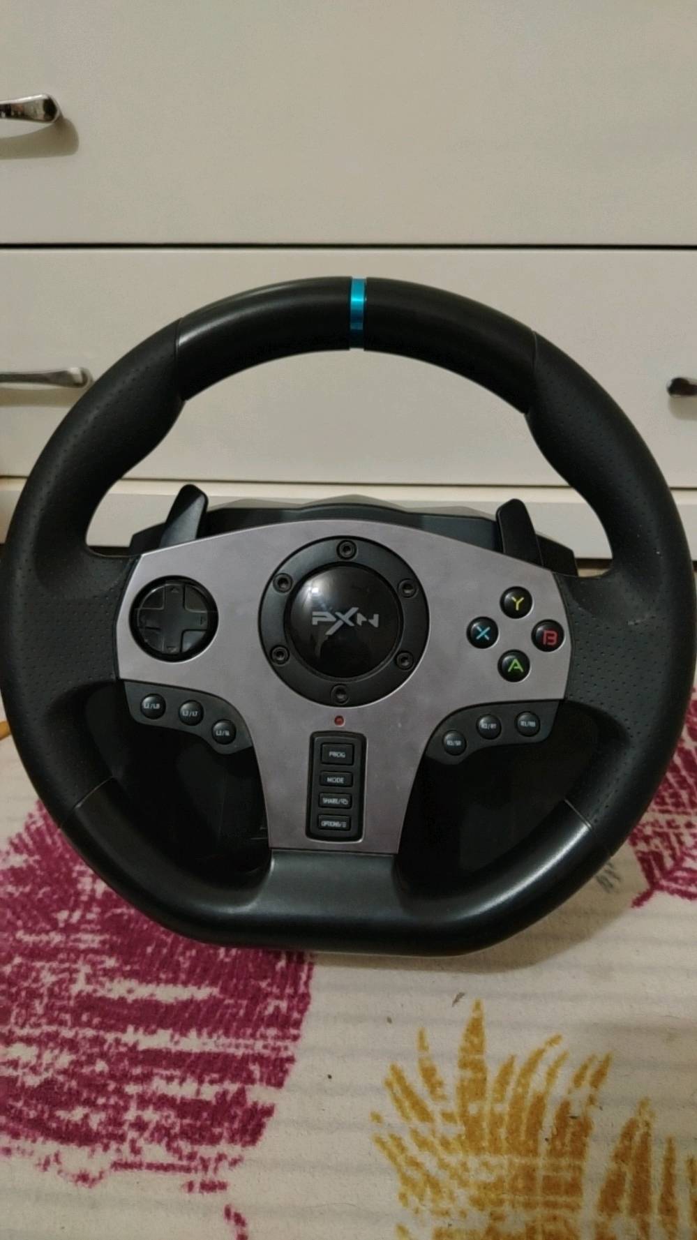 ملاحظة: الجهاز مستخدم بشكل قليل جداً 
🎮🔥 دركسون الألعاب PXN V9 🔥🎮

🚗 عِش تجربة القيادة وكأنك داخل السيارة مع دركسون PXN V9، المصمم لمحبي ألعاب السيارات والقيادة.

🔹 الموديل: PXN V9
🔹 الاتصال: USB سلكي
🔹 زاوية الدوران: 270° / 900° قابلة للتبديل
🔹 قطر الدركسون: 280mm
🔹 خامة الدركسون: بلاستيك مع قبضة مطاطية
🔹 تبديل سرعات من خلف الدركسون: Paddle Shifters
🔹 ناقل حركة: 6 سرعات + R (6+1) بنظام H
🔹 دواسات: بنزين + فرامل + كلتش
🔹 فرامل يدوية: Handbrake Switch
🔹 أزرار قابلة للبرمجة
🔹 D-Pad + أزرار A/B/X/Y
🔹 إمكانية ضبط حساسية الدركسون
🔹 تثبيت قوي على الطاولة بواسطة المشابك
🔹 يدعم الاهتزاز في الألعاب المتوافقة
🔹 يعمل بنظام X-Input و D-Input على الكمبيوتر
🔹 يدعم تطبيق PXN Wheel على الأجهزة المتوافقة

🎮 الأجهزة المتوافقة:
✅ PC – Windows 7/8/10/11
✅ PS3
✅ PS4
✅ Xbox One
✅ Xbox Series X|S
✅ Nintendo Switch

📦 محتويات الطقم:
• دركسون PXN V9
• مجموعة دواسات 3
• ناقل حركة 6+1
• مشابك تثبيت
• كابلات التوصيل
• دليل الاستخدام

📏 حجم الدركسون: 280 × 340 × 285 mm
⚖️ الوزن: حوالي 3.28 كغم حسب صفحة المنتج الرسمية
🔌 استهلاك التشغيل: 80–150mA

🔥 مناسب لألعاب السيارات والقيادة والـ Truck Simulator والسباقات، ويعطيك تحكمًا أقرب لتجربة القيادة الحقيقية.