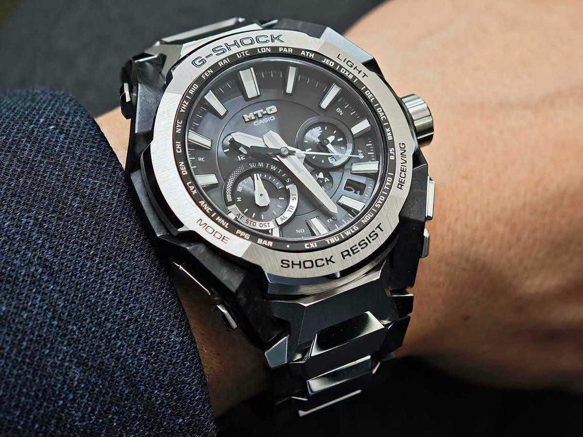 حصرياً لدى السيد للساعات 
السعر 1,500,000
Casio G-Shock MT-G Series 
وهي واحدة من السلسلة الفاخرة اليابانية MT-G التي تجمع بين المتانة الفائقة والتصميم الهيكلي الأنيق باستخدام مزيج من المعدن وألياف الكربون. تم تطوير هندسة هذه السلسلة الفريدة بالتعاون مع تقنيات الذكاء الاصطناعي لتحسين توزيع الوزن وزيادة مقاومة الصدمات.
 كافة التفاصيل، المواصفات، والمميزات الأساسية لهذه الساعة:
. التقنيات الذكية والاتصال (الأعلى تعقيداً)
• اتصال ذكي (Bluetooth® Mobile Link): تتصل الساعة لاسلكياً بالهاتف الذكي عبر تطبيق CASIO WATCHES. يتيح ذلك ضبط الوقت تلقائياً بدقة متناهية، وإعداد الساعة بسهولة، وميزة "الباحث عن الهاتف" (Phone Finder).
• التحكم اللاسلكي بالموجات (Multi-Band 6): تستقبل الساعة إشارات راديو لمعايرة الوقت تلقائياً من 6 محطات بث حول العالم لضمان دقة متناهية حتى بدون هاتف.
• نظام الطاقة الشمسية (Tough Solar): نظام شحن متطور يعمل بالطاقة الشمسية أو أي مصدر ضوء آخر، مما يلغي الحاجة لتغيير البطارية دورياً.
2. البنية والمواد التصنيعية (هندسية متقدمة)
• هيكل حماية النواة المزدوجة (Dual Core Guard): هيكل متطور يدمج بين الراتينج المعزز بألياف الكربون والفولاذ المقاوم للصدأ (Stainless Steel) لحماية الآلية الداخلية من أقوى الصدمات.
• حزام مركب من طبقات (Layered-Composite Band): سوار فاخر مصنوع من قطع معدنية مدمجة مع قطع الراتينج ليوفر وزناً خفيفاً وملمساً مريحاً على اليد مع الحفاظ على المظهر الصلب.
• زجاج ياقوتي (Sapphire Crystal): زجاج فائق النقاء ومقاوم للخدش بنسبة عالية جداً، مزود بطبقة طلاء مضادة للانعكاس لرؤية واضحة في مختلف ظروف الإضاءة.
3. الوظائف الرياضية واليومية (متوسطة التعقيد)
• التوقيت العالمي المتعدد: يدعم 38 منطقة زمنية (تغطي 27 مدينة رئيسية + التوقيت العالمي المنسق UTC)، مع خاصية التبديل التلقائي للتوقيت الصيفي (DST).
• التقويم التلقائي الكامل: يعرض التاريخ واليوم بدقة ولا يحتاج للتعديل حتى في السنوات الكبيسة.
• مؤقت وساعة إيقاف (Stopwatch): لحساب الوقت بدقة أثناء التمارين أو الأنشطة اليومية.
4. المواصفات الأساسية (الأبسط)
• مقاومة الماء حتى 200 متر (20 Bar): تجعلها مناسبة جداً للسباحة، الغوص السطحي، والأنشطة المائية القوية.
• إضاءة LED عالية السطوع (Super Illuminator): تضمن قراءة الوقت بوضوح تام في الظلام الدامس.
• عقارب مضيئة (Neobrite): طلاء فوسفوري على العقارب والمؤشرات يضيء في الظلام بعد تعرضه القصير للضوء.
