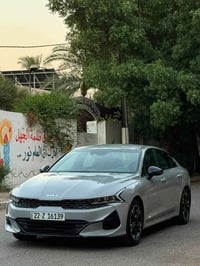 كيا كي فايف موديل ٢٠٢٣ لون اسمنتي داخل جلد احمر فول مواصفات عدا الفتحة...