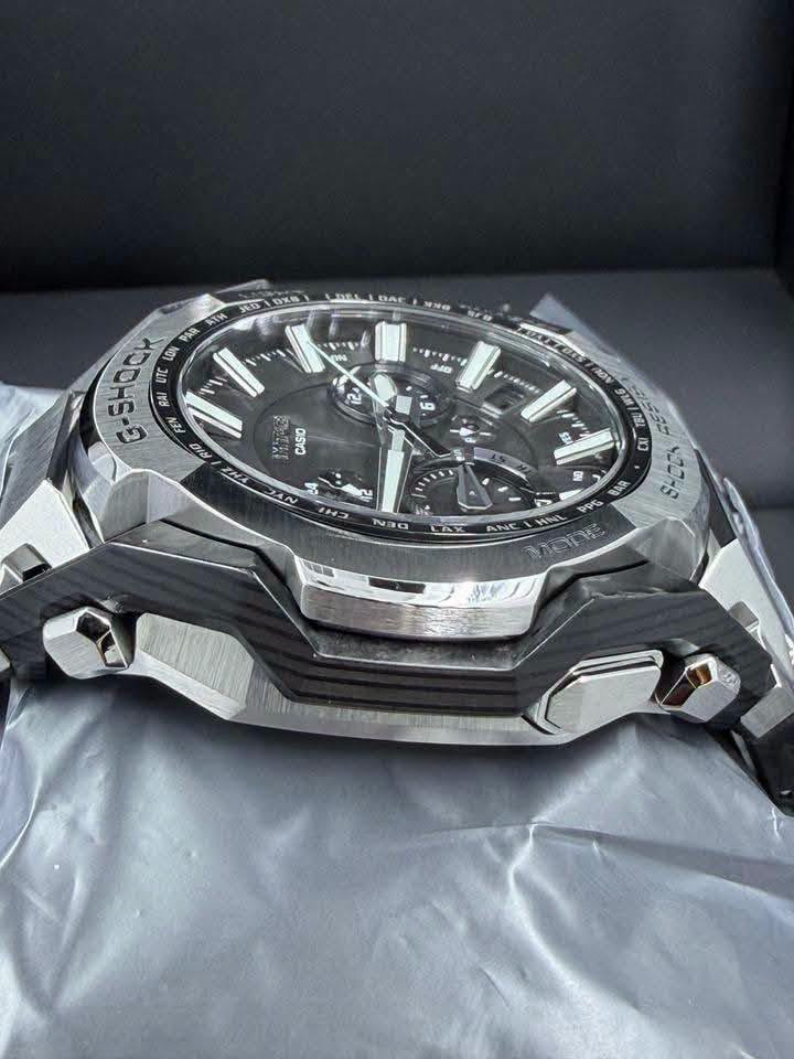 حصرياً لدى السيد للساعات 
السعر 1,500,000
Casio G-Shock MT-G Series 
وهي واحدة من السلسلة الفاخرة اليابانية MT-G التي تجمع بين المتانة الفائقة والتصميم الهيكلي الأنيق باستخدام مزيج من المعدن وألياف الكربون. تم تطوير هندسة هذه السلسلة الفريدة بالتعاون مع تقنيات الذكاء الاصطناعي لتحسين توزيع الوزن وزيادة مقاومة الصدمات.
 كافة التفاصيل، المواصفات، والمميزات الأساسية لهذه الساعة:
. التقنيات الذكية والاتصال (الأعلى تعقيداً)
• اتصال ذكي (Bluetooth® Mobile Link): تتصل الساعة لاسلكياً بالهاتف الذكي عبر تطبيق CASIO WATCHES. يتيح ذلك ضبط الوقت تلقائياً بدقة متناهية، وإعداد الساعة بسهولة، وميزة "الباحث عن الهاتف" (Phone Finder).
• التحكم اللاسلكي بالموجات (Multi-Band 6): تستقبل الساعة إشارات راديو لمعايرة الوقت تلقائياً من 6 محطات بث حول العالم لضمان دقة متناهية حتى بدون هاتف.
• نظام الطاقة الشمسية (Tough Solar): نظام شحن متطور يعمل بالطاقة الشمسية أو أي مصدر ضوء آخر، مما يلغي الحاجة لتغيير البطارية دورياً.
2. البنية والمواد التصنيعية (هندسية متقدمة)
• هيكل حماية النواة المزدوجة (Dual Core Guard): هيكل متطور يدمج بين الراتينج المعزز بألياف الكربون والفولاذ المقاوم للصدأ (Stainless Steel) لحماية الآلية الداخلية من أقوى الصدمات.
• حزام مركب من طبقات (Layered-Composite Band): سوار فاخر مصنوع من قطع معدنية مدمجة مع قطع الراتينج ليوفر وزناً خفيفاً وملمساً مريحاً على اليد مع الحفاظ على المظهر الصلب.
• زجاج ياقوتي (Sapphire Crystal): زجاج فائق النقاء ومقاوم للخدش بنسبة عالية جداً، مزود بطبقة طلاء مضادة للانعكاس لرؤية واضحة في مختلف ظروف الإضاءة.
3. الوظائف الرياضية واليومية (متوسطة التعقيد)
• التوقيت العالمي المتعدد: يدعم 38 منطقة زمنية (تغطي 27 مدينة رئيسية + التوقيت العالمي المنسق UTC)، مع خاصية التبديل التلقائي للتوقيت الصيفي (DST).
• التقويم التلقائي الكامل: يعرض التاريخ واليوم بدقة ولا يحتاج للتعديل حتى في السنوات الكبيسة.
• مؤقت وساعة إيقاف (Stopwatch): لحساب الوقت بدقة أثناء التمارين أو الأنشطة اليومية.
4. المواصفات الأساسية (الأبسط)
• مقاومة الماء حتى 200 متر (20 Bar): تجعلها مناسبة جداً للسباحة، الغوص السطحي، والأنشطة المائية القوية.
• إضاءة LED عالية السطوع (Super Illuminator): تضمن قراءة الوقت بوضوح تام في الظلام الدامس.
• عقارب مضيئة (Neobrite): طلاء فوسفوري على العقارب والمؤشرات يضيء في الظلام بعد تعرضه القصير للضوء.
