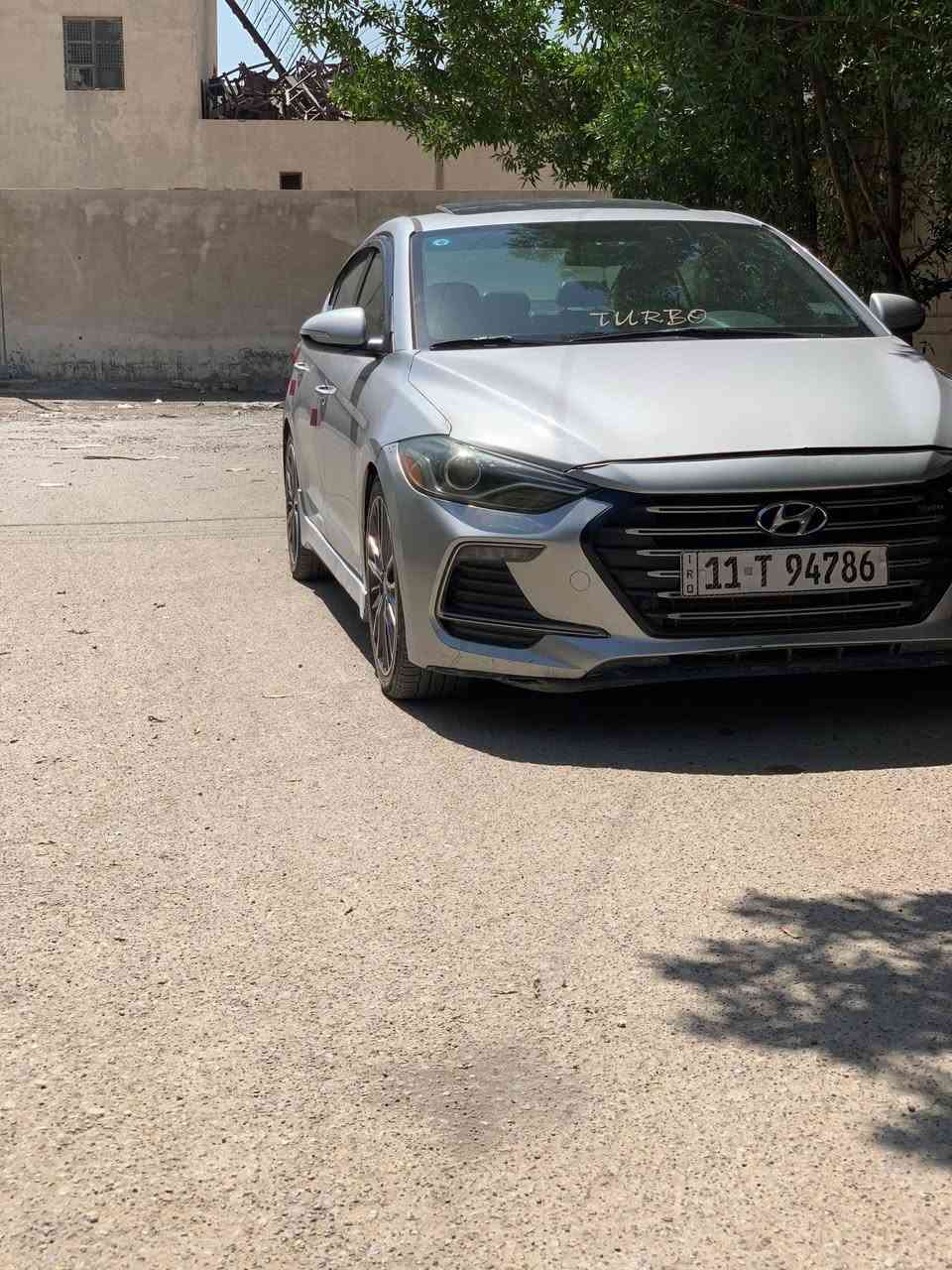 هيونداي النترا 2018 سبورت 1.6 تيربو (وارد أمريكي) – فول مواصفات 🚗
✨ المحرك والأداء

* محرك 1.6 لتر تيربو GDI
* 4 سلندر – حقن مباشر
* قوة 201 حصان
* عزم 265 نيوتن متر (195 رطل/قدم)
* قير أوتوماتيك DCT من 7 سرعات أو يدوي 6 سرعات
* دفع أمامي FWD
* تسارع 0-100 كم/س حوالي 7 ثوانٍ
* وضعية قيادة رياضية Sport Mode  

✨ المواصفات الخارجية

* جنوط رياضية ألمنيوم قياس 18 إنج
* إطارات 225/40 R18
* مصابيح HID أمامية
* LED خلفية
* مرايا كهربائية مع إشارات
* شبك سبورت وتصميم رياضي خاص بفئة Sport
* جناح خلفي رياضي
* فتحة سقف كهربائية

✨ المواصفات الداخلية

* مقاعد جلد رياضية
* مقاعد أمامية مدفأة
* مقود جلد رياضي Flat Bottom
* تشغيل بصمة (Smart Key)
* تشغيل السيارة زر Start/Stop
* شاشة معلومات وسطية
* Apple CarPlay
* Android Auto
* بلوتوث
* USB و AUX
* مثبت سرعة
* تكييف أوتوماتيك
* شاشة معلومات بين العدادات  

✨ أنظمة الأمان

* 6 وسائد هوائية
* ABS مانع انغلاق الفرامل
* ESP نظام الثبات الإلكتروني
* Traction Control
* كاميرا خلفية
* Blind Spot Monitor (تحذير النقطة العمياء)
* Rear Cross Traffic Alert
* Hill Start Assist
* نظام مراقبة ضغط الإطارات TPMS  

✨ مواصفات الشاصي والتعليق

* تعليق رياضي Sport Tuned Suspension
* نظام تعليق خلفي مستقل Multi-Link
* دسكات أمامية كبيرة رياضية
* توجيه كهربائي دقيق EPS
* ثبات ممتاز على السرعات العالية
رقم بغداد Eنكليزي تحويل ثاني يوم
مكان بغداد البياع السعر 103 ابيع سريع
***********
