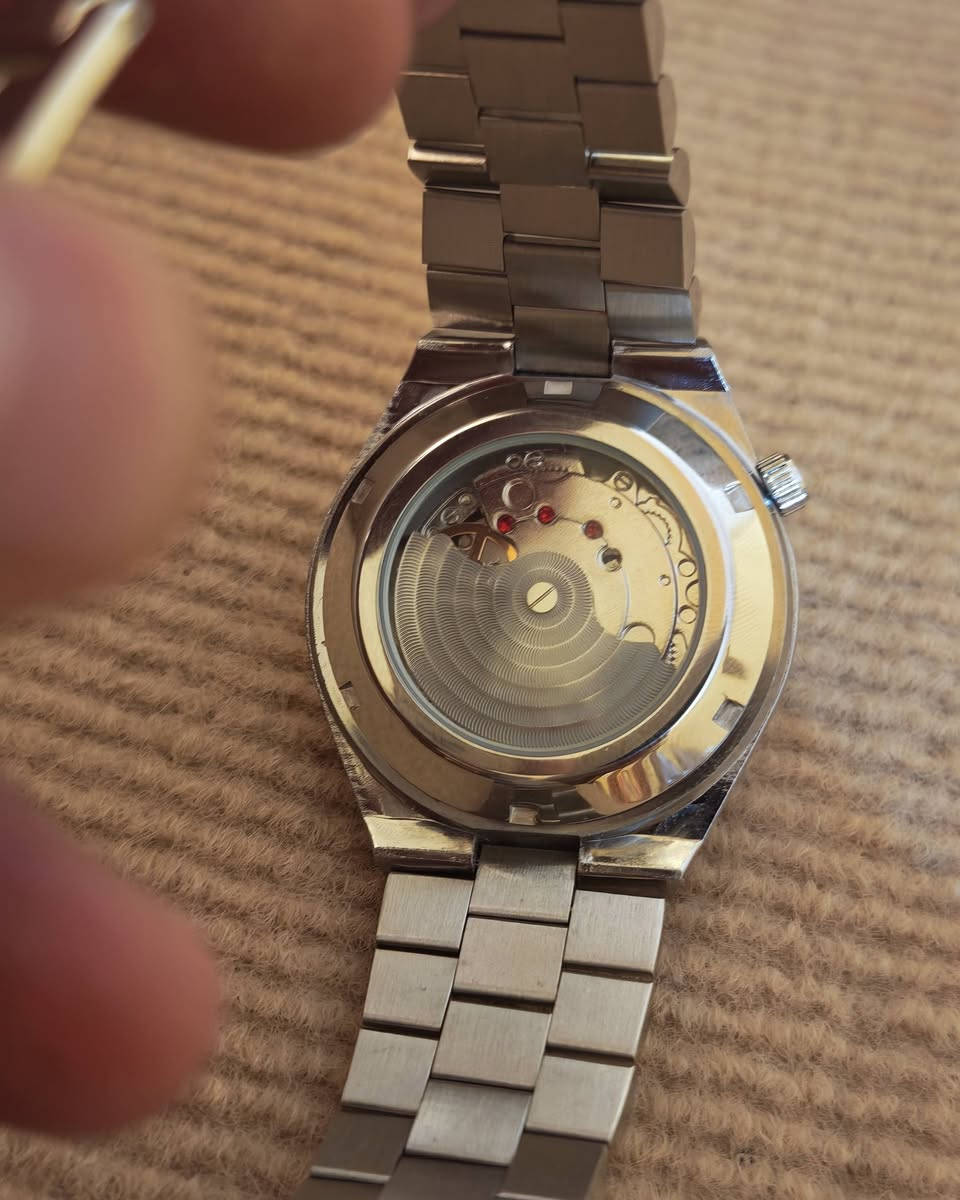 يا الله
ساعة سيتيزن (Citizen)، وتحديداً من مجموعة تسويوسا أوتوماتيك (Tsuyosa Automatic) الشهيرة.المواصفات الأساسية للساعة:نوع الحركة: أوتوماتيكية (تلقائية) تعمل بحركة المعصم.قطر العلبة: 40 ملم.مادة الصنع: فولاذ مقاوم للصدأ (ستانلس ستيل) للعلبة والسوار.تصميم المينا: مينا باللون الرمادي الداكن مع عقارب ومؤشرات ساعات ذات لمعان ذهبي أنيق.نافذة التاريخ: تقع عند مؤشر الساعة 3 مع عدسة مكبرة لقراءة التاريخ بسهولة.مقاومة الماء: مناسبة للاستخدام اليومي البسيط ورذاذ الماء (حتى عمق 50 متراً).
***********
