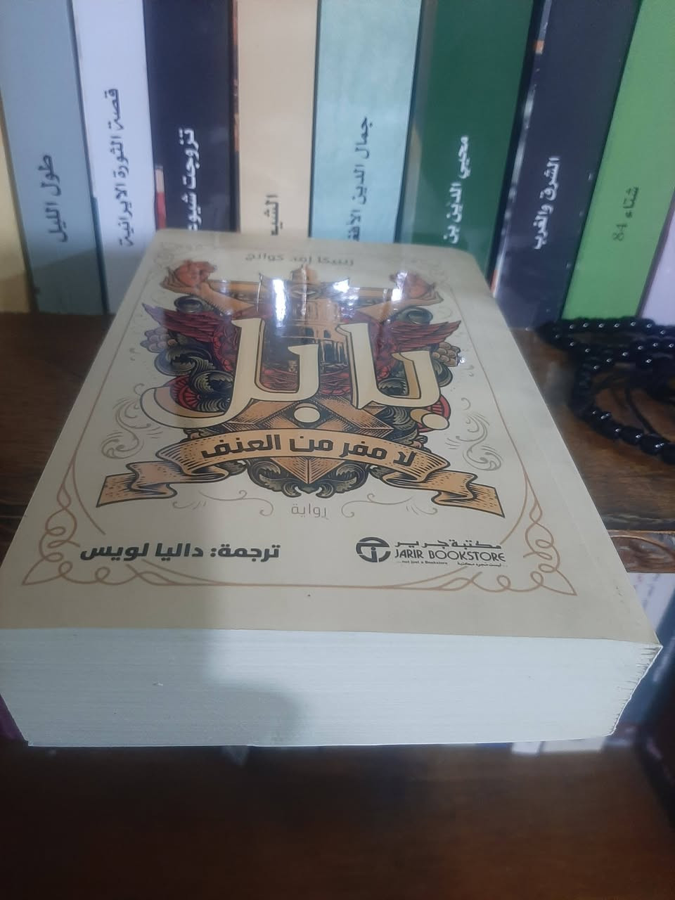 في رواية «بابل: أو ضرورة العنف» تقدّم الكاتبة ر. ف. كوانغ عملاً يتجاوز حدود الفانتازيا ليغوص في سؤال أخلاقي عميق: هل يمكن مقاومة الظلم دون عنف؟ أم أن العنف يصبح، في لحظة تاريخية معينة، حتميًا؟

تدور الرواية في عالم بديل يستند إلى القرن التاسع عشر، حيث تُبنى قوة الإمبراطورية البريطانية على سحر الترجمة. في معهد “بابل” بجامعة أكسفورد، تتحول اللغة من وسيلة للتفاهم إلى أداة للهيمنة، ويغدو المترجمون جنودًا غير مرئيين في خدمة مشروع استعماري واسع. هنا، لا تُسرق الثروات فقط، بل تُستغل اللغات والثقافات نفسها لإدامة السيطرة.

من خلال رحلة بطلها، الشاب القادم من الشرق، تكشف الرواية التناقض القاسي بين الامتياز الشخصي والانتماء الأخلاقي. فكلما تعمّق في هذا العالم، أدرك أن المعرفة التي يسعى إليها ليست بريئة، وأنه جزء من منظومة تقوم على استغلال شعوب أخرى. هذا الإدراك يضعه أمام خيار صعب: القبول بدوره داخل النظام، أم التمرد عليه مهما كان الثمن.

ما يميز «بابل» هو طرحها الصريح لفكرة أن الأنظمة الظالمة لا تُصلح بسهولة من الداخل. فالإمبراطورية، كما تصورها الرواية، لا تستجيب للخطاب الأخلاقي بقدر ما تستجيب للقوة. ومن هنا ينبثق العنوان الفرعي: «ضرورة العنف»، بوصفه ليس دعوة إليه، بل توصيفًا لواقع تاريخي تتعطل فيه الوسائل السلمية.

في النهاية، لا تقدّم الرواية إجابة جاهزة، بل تترك القارئ أمام مرآة فكرية: هل يمكن للعدالة أن تتحقق دون صدام؟ أم أن كل تغيير جذري يحمل في طياته قدرًا من العنف؟ بين اللغة والسلطة، وبين المعرفة والاستعمار، تضع «بابل» سؤالها المفتوح، وتغادر تاركة أثرًا لا يُمحى
📚.بابل
لامفر من العنف 
✍ربيكا اف كوانج
٥٨٠ص
💸السعر:  5.000
الف....
رئاسة العبيدي 
او 
المتنبي يوم الجمعة
***********
