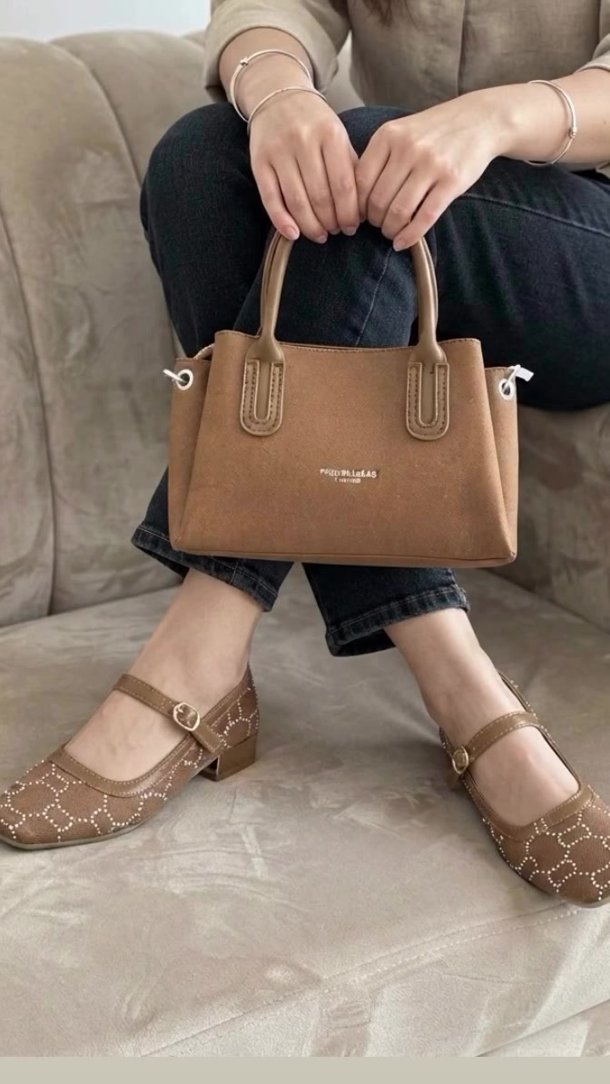 أضيفي لمسة من الأناقة والرقي لإطلالتك اليومية مع هذا الثنائي المثالي! 😍
👠 الحذاء 
حذاء ماري جين العصري بالكعب العريض ليمنحكِ الراحة والثبات طوال اليوم، مع تفاصيل الأبازيم المزدوجة والزهرة الكريستالية الصغيرة التي تضفي لمسة أنثوية ساحرة. اللون البيج الكريمي يتناغم مع كل شيء 
👜 الجنطة جنطة بتصميم كلاسيكي فخم، مصنوعة من نسيج بارز (Tweed) وقاعدة بيضاء ناعمة، مع إبزيم ذهبي مميز (GD) يعكس الفخامة. حجمها مثالي لكل أغراضك الأساسية
