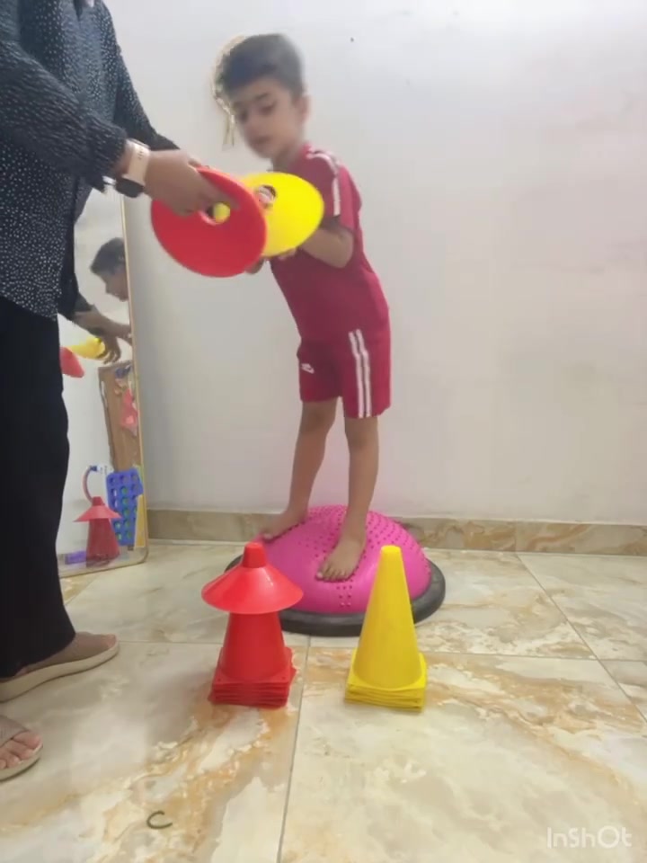 نشاط التكامل الحسي ...
👈 بواسطة وسادة التوازن 
 من فوائده 👇
1. تحسين التوازن والثبات من خلال الوقوف على وسادة التوازن، مما يقوي عضلات الجذع والساقين.
2. تنمية التآزر الحركي بين العين واليد أثناء التقاط الأقماع ووضعها في المكان المناسب.
3. تطوير التركيز والانتباه لأن الطفل يحتاج إلى المحافظة على توازنه مع تنفيذ المهمة.
4. تعزيز الإدراك البصري من خلال التمييز بين الألوان أو مطابقة الأقماع.
5. تنمية التخطيط الحركي (Motor Planning) عبر ترتيب خطوات النشاط وتنفيذها بالتسلسل.
6. تحفيز الجهاز الدهليزي والحس العميق (Vestibular & Proprioceptive)، مما يساعد على تحسين تنظيم المدخلات الحسية لدى الأطفال الذين يعانون من صعوبات حسية.
7. زيادة التوافق بين نصفي الدماغ نتيجة دمج الحركة مع المهام الإدراكية.
8. تنمية مهارات اتباع التعليمات مثل: “ضع الأحمر هنا، ثم الأصفر هناك”.
9. تعزيز الثقة بالنفس عندما ينجح الطفل في المحافظة على توازنه وإنهاء المهمة.
10. تحسين القدرة على أداء مهام متعددة من خلال الجمع بين التوازن، والتركيز، والتصنيف في نشاط واحد.
#مركز_الخطوة_الأولى_لعلاج_مشاكل_الأطفال
👈خيارك الأمثل لتطور طفلك
عنواننا / الشهداء .. خلف المدرسة الألمانية
للأستفسار /***********
#اضطراب_طيف_التوحد
#تأخر_النطق
#تعديل_سلوك
