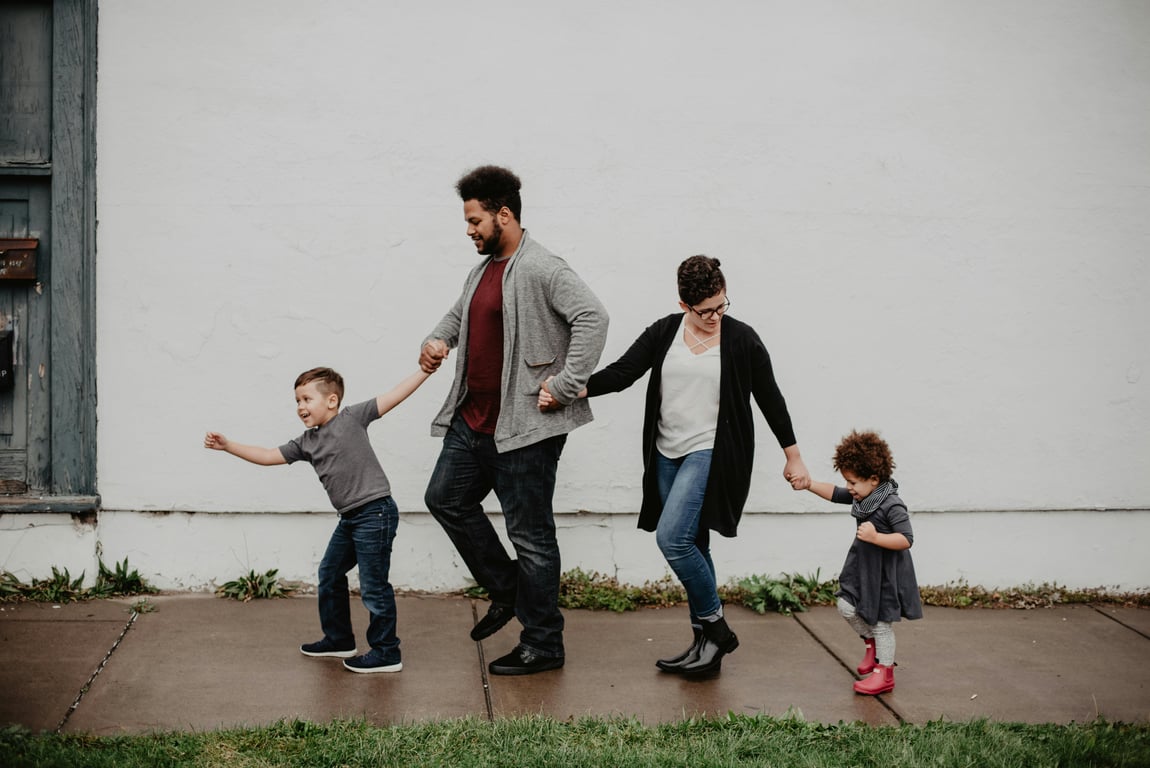 family walking on a sidewalk