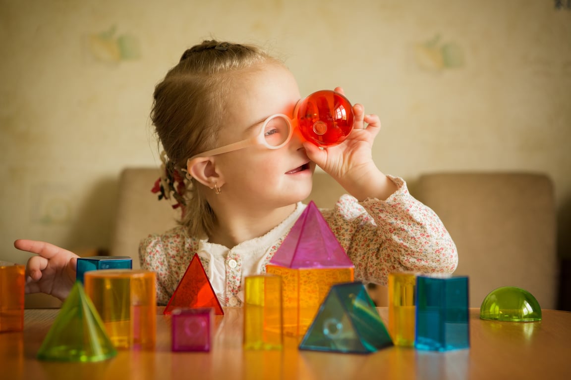 Girl with Down syndrome playing with geometrical shapes