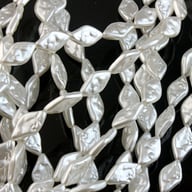 Close-up white baroque pearl ABS beads on black surface showing lustrous finish