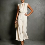 Woman in cream sleeveless two-piece set with wide-leg cropped pants and gold jewelry