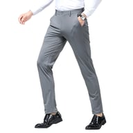 Man wearing black high-elasticity slim fit dress pants, walking isolated background