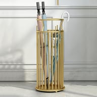 Modern gold umbrella stand with multiple umbrellas against white wall backdrop