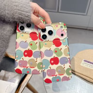 Two colorful apple pattern phone cases resting on table, electroplated finish visible