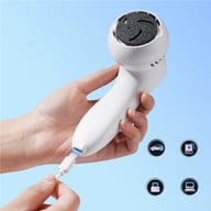 Hand holding white electric foot grinder charging with USB cable