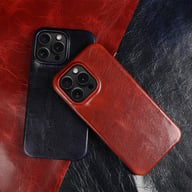 Two premium leather iPhone cases in red and blue on textured leather background