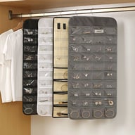 Four hanging jewelry organizers in black, white, beige, and gray filled with accessories