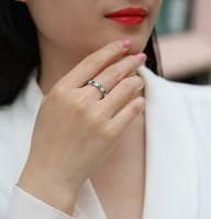 Woman wearing green and white gemstone stackable eternity ring