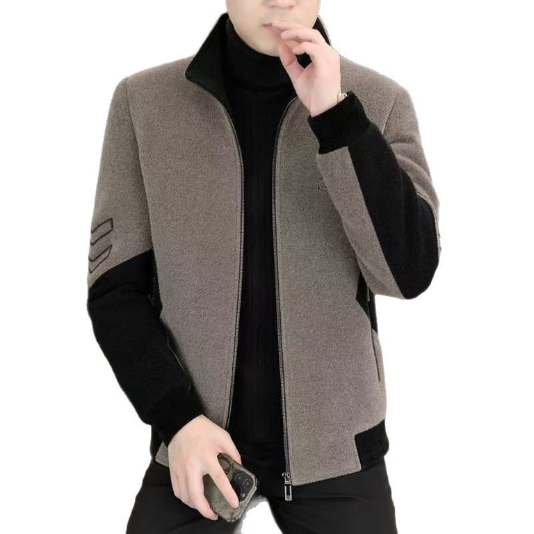 Man in grey and black stand-neck jacket holding phone, demonstrating everyday wearability