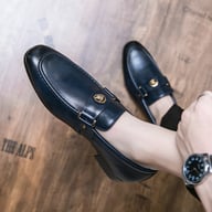 Navy blue slip-on loafers with metal buckle embellishment detail