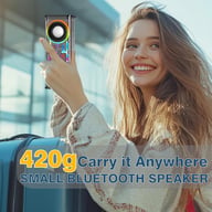 Woman holding compact Bluetooth speaker next to travel suitcase