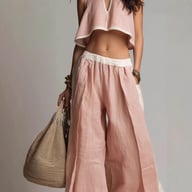 Close-up detail of pink crop top V-neckline and wide-leg pants outfit