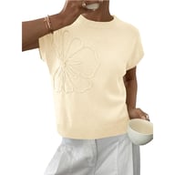 Woman wearing cream jacquard flower sweater holding small bowl, comfortable everyday look